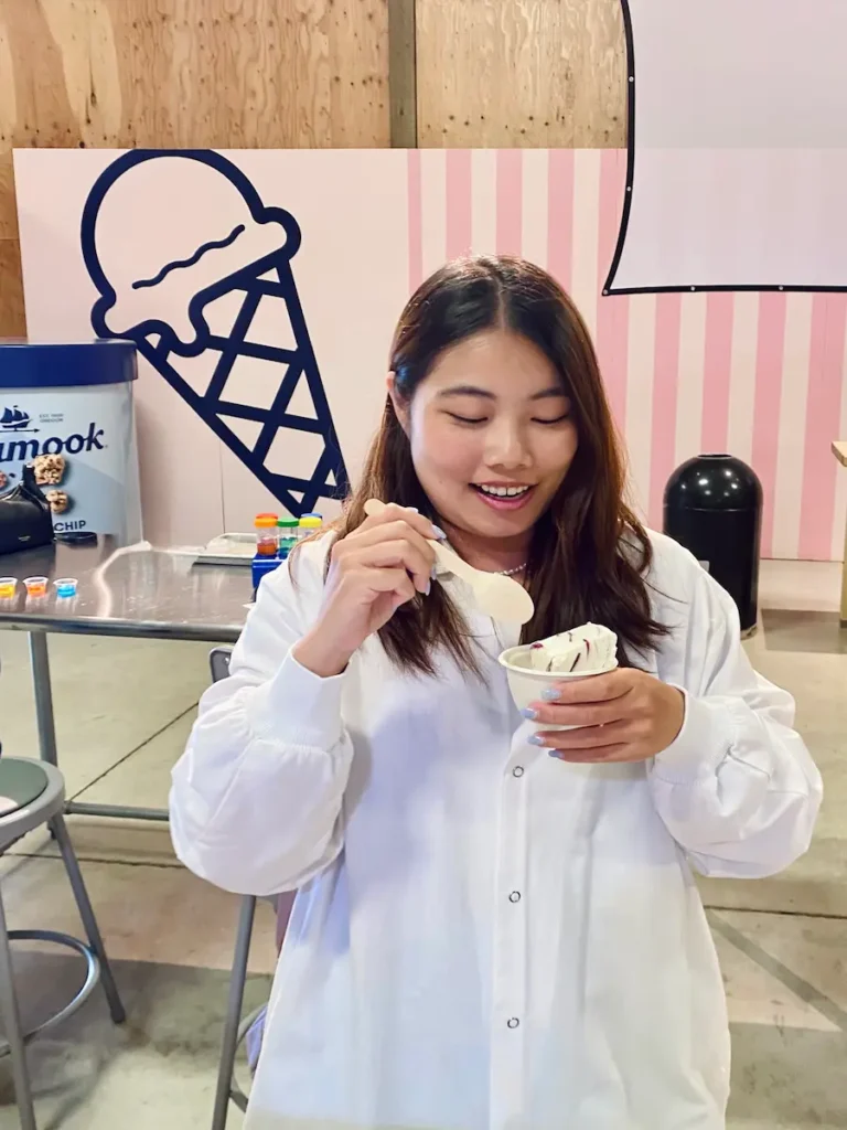 Solo traveler enjoying a scoop of ice cream during a Tillamook Factory tour in Oregon, a fun travel activity.