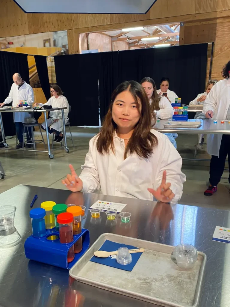 Solo traveler in a white lab coat doing a hands-on ice cream flavor test at Tillamook Factory in Oregon.
